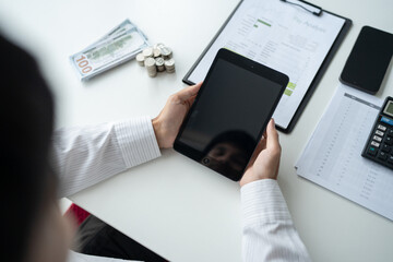 Business man holding digital tablet using Stock market application and reviews finances and manages budget with money cash
