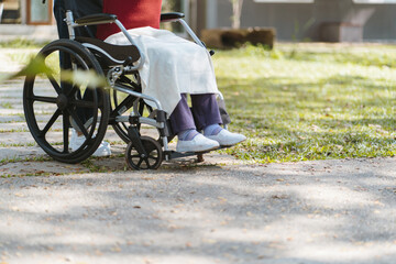Nursing home. Young caregiver helping senior woman in wheelchair.