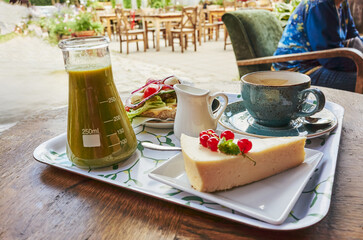 Tray of food and a glass of juice sits on a table