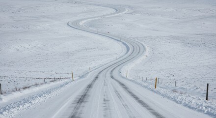 Obraz premium Serpentine route through snow-laden expanses evoking remote winter landscapes
