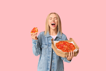 Young happy woman holding cardboard box with tasty pizza on pink background