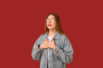 Beautiful young woman meditating on red background. Zen concept