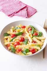 Pasta casarecce with tomatoes, basil and cheese. Italian cuisine. Vegetarian food.