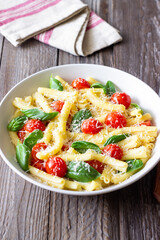 Pasta casarecce with tomatoes, basil and cheese. Italian cuisine. Vegetarian food.