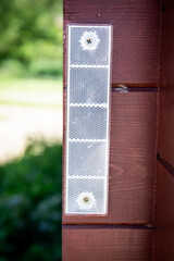 Close-Up of Mounted Reflector Panel on Wooden Wall in Sunlight