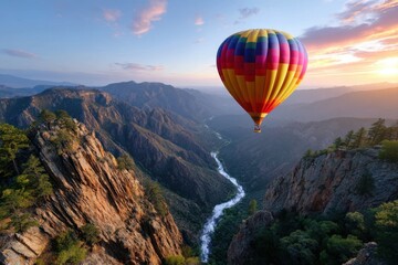 Obraz premium Colorful hot air balloon flying over a winding river and mountains during sunset