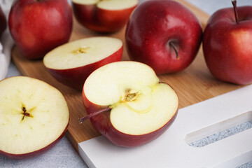 Board with fresh red apples on white background, closeup