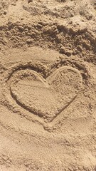 A heart shape drawn in the sand on a beach