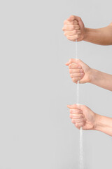Many hands with pouring sand on grey background. Time concept