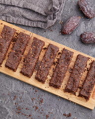 Chocolate date protein bars with amaranth on wooden board