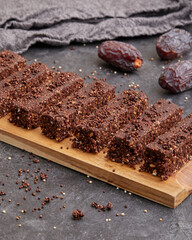 Chocolate date protein bars with amaranth on wooden board