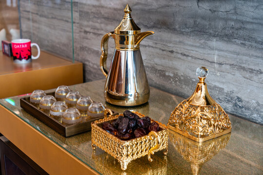 golden coffeepot, coffee mug and dates. Drinking coffee in Arabic style. Coffee house