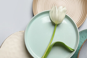 Beautiful table setting with white tulip on grey background