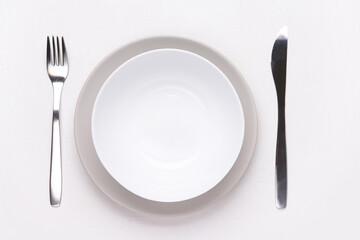 Table setting with clean plates and cutlery on white background