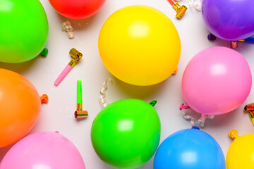 Balloons, confetti and noisemakers on white background