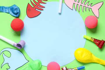 Blank card with paper fishes and party decor on green background. April Fools Day celebration