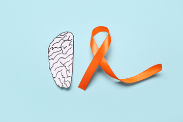 Paper brain and orange ribbon on blue background. Multiple Sclerosis Awareness Month