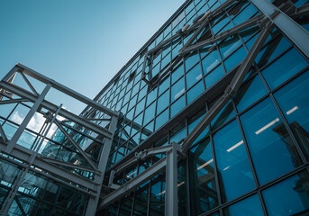 Obraz premium Modern Architectural Building with Steel Frame, Glass Windows, and Blue Sky, Office Exterior.
