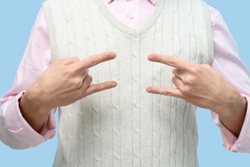 Young deaf mute man using sign language on blue background, closeup