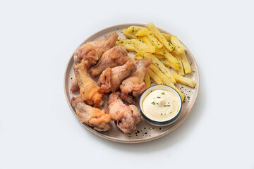 Chicken legs and wings with sauce on a plate on a white background