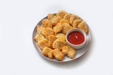 Breaded chicken nuggets with sauce and salad on a plate on a white background