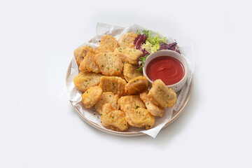 Breaded chicken nuggets with sauce and salad on a plate on a white background