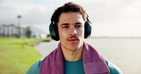 Fitness, music and thinking with man outdoor for break from cardio challenge or intense training. Breathing, headphones and towel with tired athlete at lake for exercise or recovery from workout