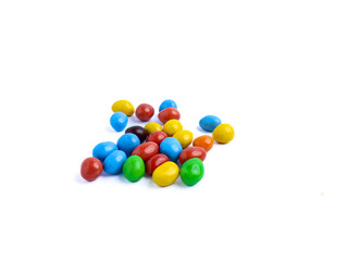 Colorful candy-coated chocolate pieces scattered on a white background