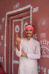 Young Indian farmer showing finger after voting