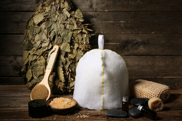 Composition with different accessories and cosmetics for sauna on wooden background