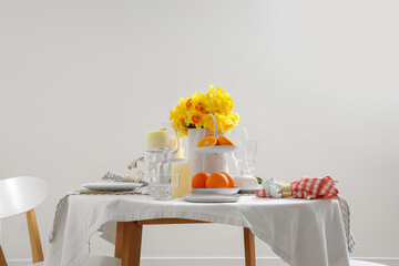 Beautiful table setting with yellow daffodils for wedding celebration in room