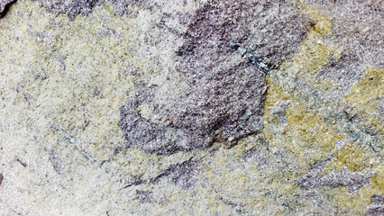 Close-up of a natural mountain rock surface featuring rough and organic textures. Ideal for use in...