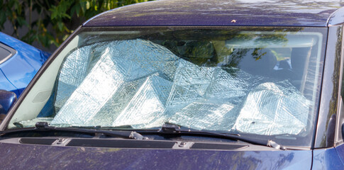 A car window is covered with a tarp