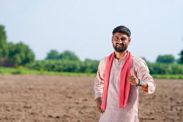 indian farmer standing at agricultural field