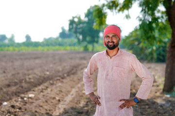 indian farmer standing at agricultural field