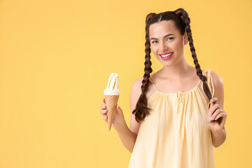 Beautiful young happy woman with braids holding tasty ice cream on yellow background