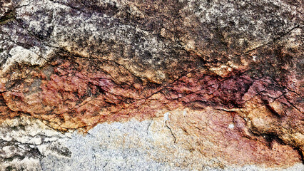 Close-up of a natural mountain rock surface featuring rough and organic textures. Ideal for use in backgrounds, design elements.