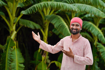 young indian farmer standing at banana field