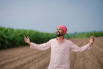 indian farmer standing at agricultural field