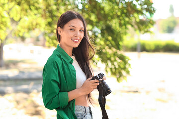 Female Asian photographer with camera outdoors