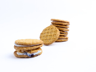 Stack of sandwich cookies with cream and blueberry filling on a white background