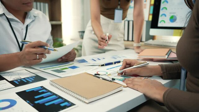 Business people working together in modern office, analyzing financial data and reports during a productive meeting