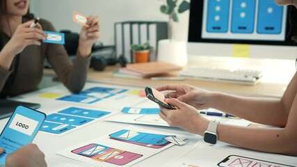 Web designers collaborating during user interface and user experience testing of mobile application prototype, analyzing design strategies and interaction workflows in modern office environment - Powered by Adobe