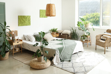 Stylish bedroom with comfortable bed and houseplants