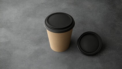 A top-down view of a disposable coffee cup and lid on a textured surface.  The cup is light brown cardboard, and the lid is black plastic.  A second lid lies beside the cup