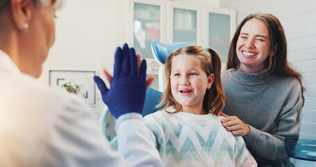 Child, dentist and high five for oral hygiene or teeth health with advice from orthodontist. Happy...