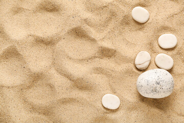 Different pebbles on beige beach sand
