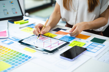UX developer and ui designer brainstorming about mobile app interface wireframe design with...
