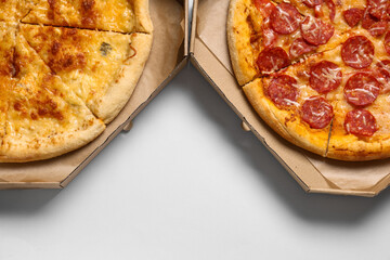 Cardboard boxes with tasty pizza on white background