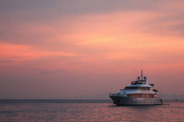 sleek yacht silhouetted against stunning sunset featuring minimalist design